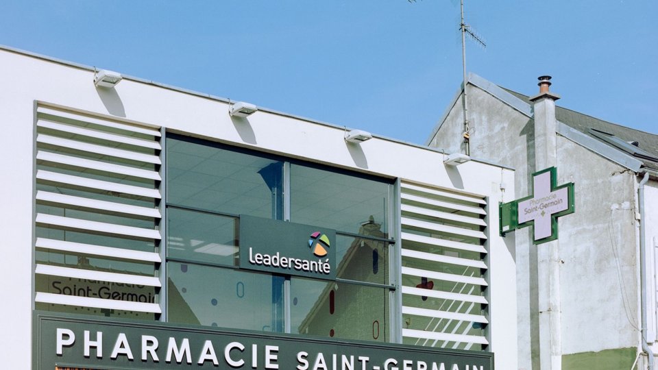 Croix de pharmacie verte illuminée de nuit