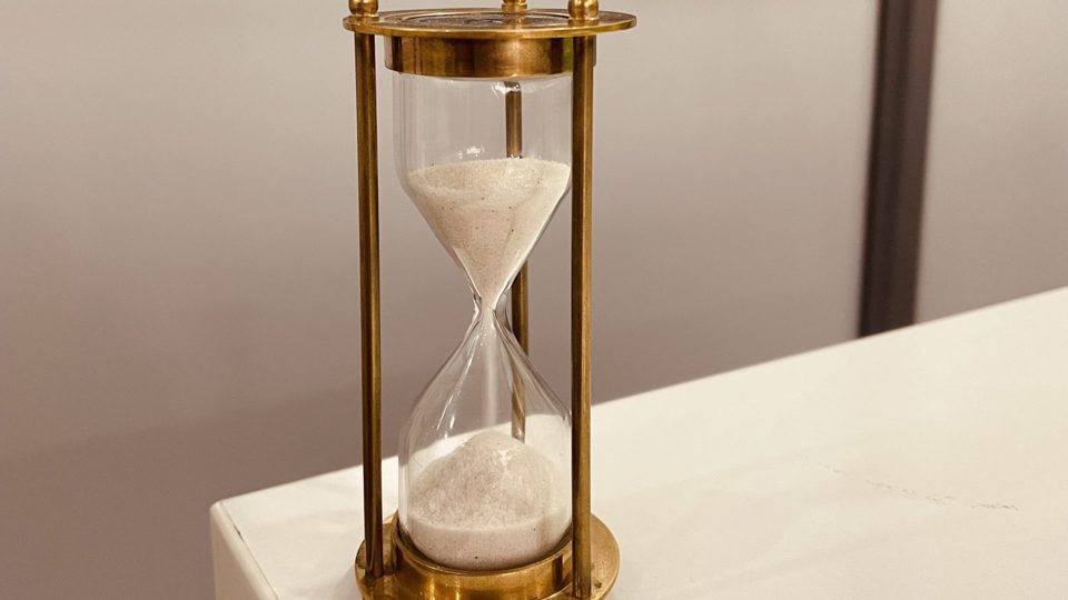 Sablier ancien en laiton, le sable presque écoulé