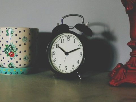 Réveil à cloches sur une table de nuit